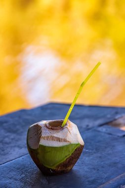 Masada pipet içilen tropik yeşil hindistan cevizi kokteyli. Dikey görünüm