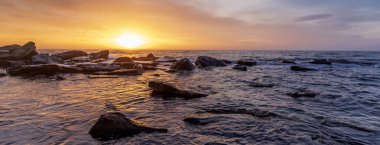 Göz kamaştırıcı panoramik manzara. Denizin üzerinde gün batımı.