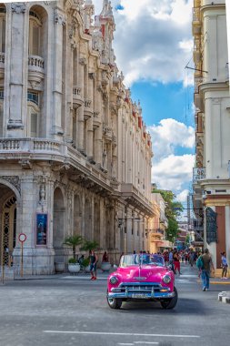 Havana, Küba - 08 Aralık 2018: Havana, Küba Büyük Tiyatrosu yakınlarındaki caddede kırmızı retro arabalı şehir manzarası