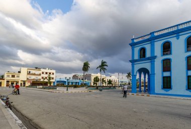 Bayamo, Küba - 12 Aralık 2018: Renkli binalarla dolu bir kasaba meydanında canlı bir sahne. Bayamo, Küba