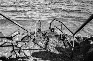 Yıpranmış taş adımlar denize doğru iniyor.