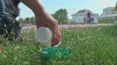 The white Labrador dog drinks from a specially designed plastic water bowl, thirstily quenching its thirst on a hot summer day in the park.