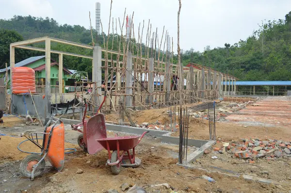 photo of unfinished building construction still in the form of earth wire and cement foundations