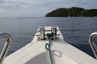 Beyaz bir yat güzel bir denizde yüzüyor. Tekneye yakın, yay, okyanustan yelken. Cennet gibi bir manzara. Turizm ve tatiller.