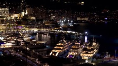 Monte Carlo Manzarası. Monako 'nun gece manzarası. Monako şehri ve Akdeniz kıyısındaki küçük eyalet. Fransa 'nın güneyinde lüks bir tatil köyü. Monako 'da pahalı yatları ve gemileri olan liman.