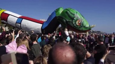 Carnival flower parade in Nice. A beautiful and noisy holiday on the azure coast. Giant dolls, flower battles. A crowd of people at the festival. Flowers are falling on heads