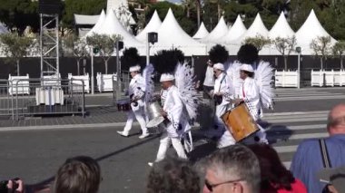 Carnival flower parade in Nice. A beautiful and noisy holiday on the azure coast. Giant dolls, flower battles. A crowd of people at the festival. Flowers are falling on heads