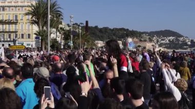 Carnival flower parade in Nice. A beautiful and noisy holiday on the azure coast. Giant dolls, flower battles. A crowd of people at the festival. Flowers are falling on heads