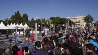 Carnival flower parade in Nice. A beautiful and noisy holiday on the azure coast. Giant dolls, flower battles. A crowd of people at the festival. Flowers are falling on heads