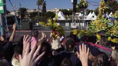 Carnival flower parade in Nice. A beautiful and noisy holiday on the azure coast. Giant dolls, flower battles. A crowd of people at the festival. People on horseback.