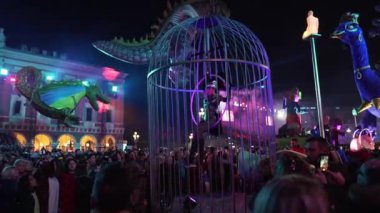 Carnival in Nice. Parade of light. Colorful images in masks. Tourists from all over the world. Parade of platforms. Papier-mch dolls, platform movement. Girl in a cage