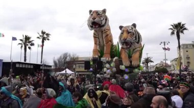 Carnival in the city of Viareggio. A parade of giant cartoon papier-mch installations. Millions of spectators, crowds of tourists. Dancers and artists in carnival costumes