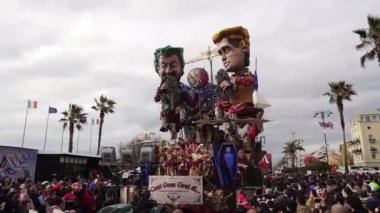 Carnival in the city of Viareggio. A parade of giant cartoon papier-mch installations. Millions of spectators, crowds of tourists. Dancers and artists in carnival costumes