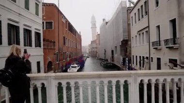 Venice is covered with fog. The capital of the region of the same name in northern Italy. Channel movement. City street on the water. People walking