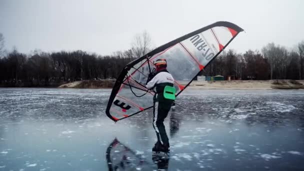 一个人带着一只手翼滑行 一个老人在结冰的湖上打滑 这位运动员正在从事一项极限运动 即滑冰 一名运动员在北欧的一个湖上滑冰 极限运动短棒 — 图库视频影像