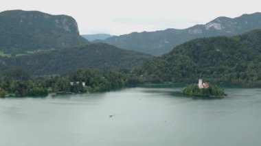 Bled Slovenya 'daki kiliseden adanın manzarası. Slovenya Kalesi 'ne gitti. Bled kenti yakınlarındaki Blajsko Gölü yakınlarındaki 130 metrelik bir uçurumun tepesindeki bir şato. Kanlı Kale ve çevresi.