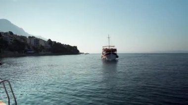 Brela Hırvatistan köyündeki Adriyatik Denizi 'nin limanından turistleri almak için rıhtıma giden bir yat gezintiye çıktı. Hırvat Adriyatik Denizi 'nde yat gezisi