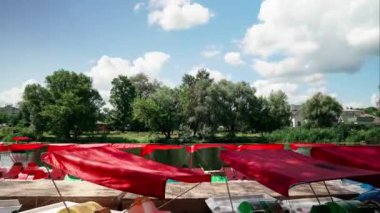 Bulutların hareket zamanı. Kıyıya yakın bir sürü katamaran var. Kuzey Avrupa 'da bir nehirde katamaranlar. Nehirde yürümek için katamaranlarla iskelede..