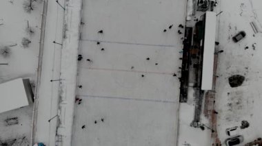 İnsanların buz pateni yaptığı kış paten pistinin insansız hava aracı görüntüsü. İnsanlar Kuzey Avrupa 'da bir hokey stadyumunda kayıyorlar. Sumy, Ukrayna 'da insanlar buz pateni pistinde eğleniyor.