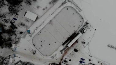 İnsanların buz pateni yaptığı kış paten pistinin insansız hava aracı görüntüsü. İnsanlar Kuzey Avrupa 'da bir hokey stadyumunda kayıyorlar. Sumy, Ukrayna 'da insanlar buz pateni pistinde eğleniyor.