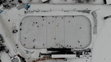 İnsanların buz pateni yaptığı kış paten pistinin insansız hava aracı görüntüsü. İnsanlar Kuzey Avrupa 'da bir hokey stadyumunda kayıyorlar. Sumy, Ukrayna 'da insanlar buz pateni pistinde eğleniyor.