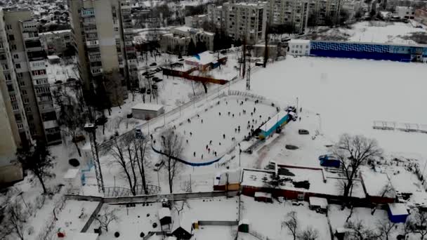 一个无人驾驶飞机拍摄的冬季溜冰场 人们在那里滑冰 人们在北欧的一个曲棍球体育场滑冰 人们在苏美市的溜冰场里玩得很开心 — 图库视频影像