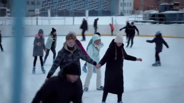 北ヨーロッパのホッケースタジアムでスケート 人々はウクライナのサミー市のスケートリンクで楽しんでいます チェーンリンクフェンスを通して見る — ストック動画