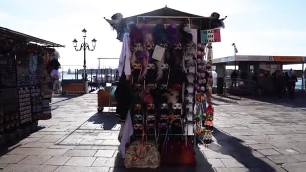 ヴェネツィアの中心部にあるヴェネツィアの仮面 イタリアのヴェネツィアのウォーターフロントで販売するためのマスク付きのストール ヴェネツィアのカーニバルマスク — ストック動画