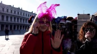 Kızlar Venedik 'teki St. Mark Meydanı' nda karnaval maskesi deniyor. Karnaval Venedik İtalya 'sını maskeliyor. Venedik 'teki Valinin Sarayı.