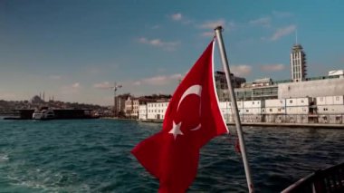 İstanbul, Türkiye 'de bir yatta Türk bayrağı. Gemi İstanbul 'daki Golden Horn Körfezi boyunca yol alıyor. Geminin güvertesinden şehrin güzel manzarası. Avrupa ile Küçük Asya arasındaki boğaz
