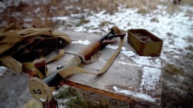 Bir kutu makineli tüfek mermisi. Masada bir sürü makineli tüfek mermisi var. Bir bomba atar, askeri eğitim alanındaki bir tarladaki bir masada cephane kutusunun yanında yatıyor.