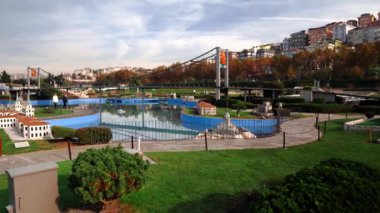 İstanbul 'daki Miniatürk Parkı' nda köprüsü olan bir yüzme havuzu. İstanbul, Türkiye 'deki Miniatürk Parkı. Mimari nesnelerin modeli. Parkta yürüyen insanlar.