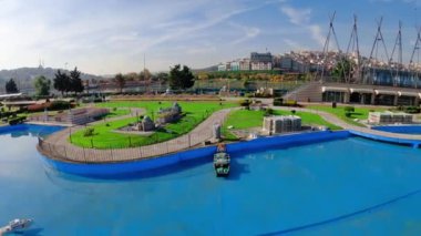 İstanbul 'daki Miniatürk Parkı' nda köprüsü olan bir yüzme havuzu. İstanbul, Türkiye 'deki Miniatürk Parkı. Mimari nesnelerin modeli. Parkta yürüyen insanlar.