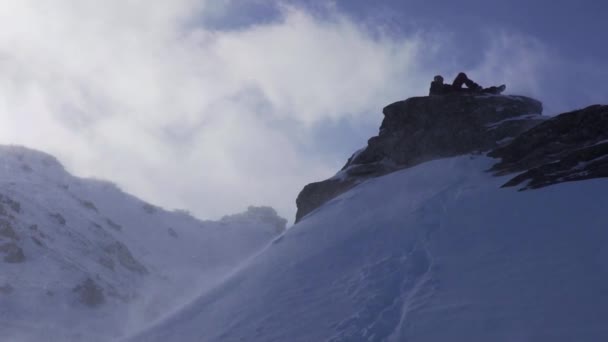 Vrolijke Wandelaar Rust Een Piek Wintersneeuw Glanzende Sneeuwvlokken Vallen Als — Stockvideo