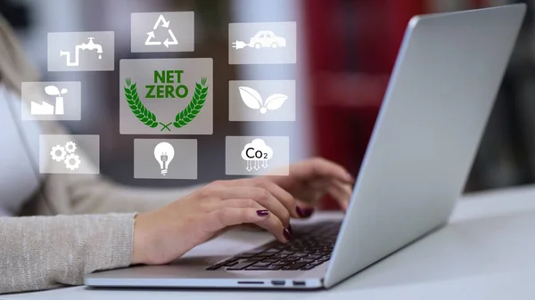 Businessman using computer to manage online information about net zero concept. natural environment neutral carbon A climate-neutral long-term strategy greenhouse gas emissions targets