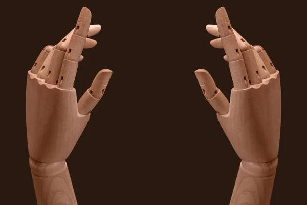 Two wooden mannequin hands on dark background. Business concept.