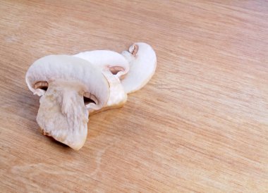 Dilimlenmiş şampiyonlar, tahta arka planda mantarlar..