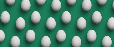 Yeşil arka planda beyaz yumurtalar. Dümdüz yemek kalıpları vardı. Sağlıklı ürünler, piyasa ve duvar kağıtları için kusursuz ve doğal tasarım ideal.