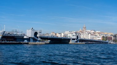 Golden Horn 'un karşısındaki Galata Köprüsü' nde yaya geçidi sokak satıcıları ve aşağıdaki kafeleri var..