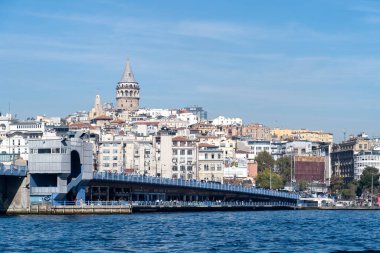 Golden Horn 'un karşısındaki Galata Köprüsü' nde yaya geçidi sokak satıcıları ve aşağıdaki kafeleri var..