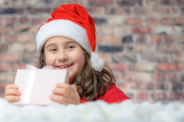 Noel Baba 'nın kırmızı kumaşlı çocuğu küçük bir hediye kutusu aç..