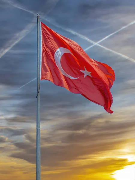 Güzel günbatımına ve rüzgarla hareket eden bulutlara karşı hindi bayrağı .