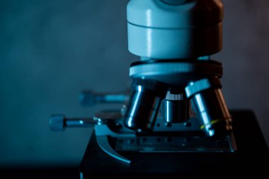 Tıbbi mikroskop lensleri sıcak mavi ışıkta yakın.