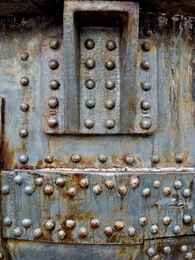 Demir ve çelik fabrikalarında büyük cıvatalar ve fındıklar, eski, paslı metal kapılar.