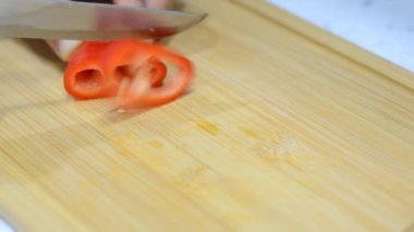 Kırmızı tatlı biberi dilimlemek, yavaş çekim ve kırmızı tatlı biberi mutfak bıçağıyla dilimleme videosunu kapat.