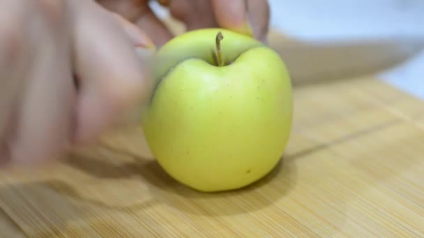 用刀片把黄苹果切成两半的镜头贴在切碎的木板上 — 图库视频影像