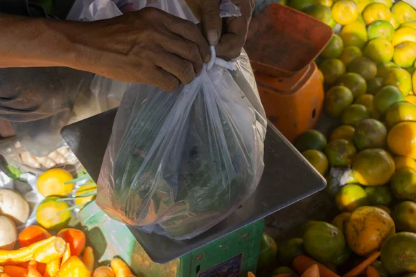 Bir sebze satıcısı eşyalarını topluyor. Geleneksel pazarda bir sebze dükkanının sahibi
