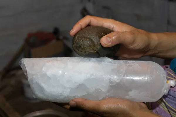 Birisi kaldırım taşı kullanarak buz küpünü kırmış. Plastik paketlenmiş buz küpleri