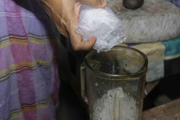 一个戴手套的女人把冰块放进搅拌机里 用刨冰做一杯清爽的饮料 — 图库照片
