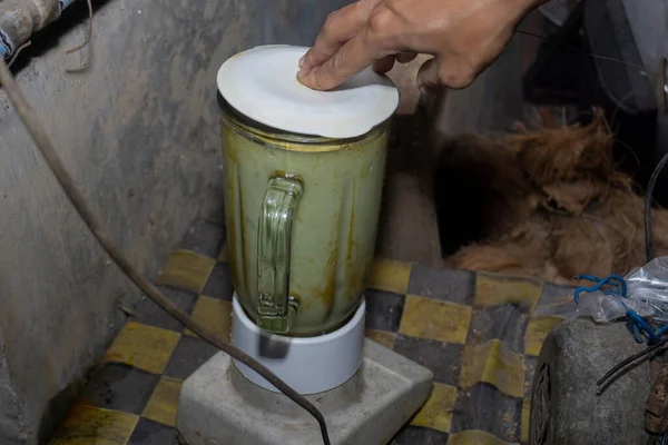 Bir kadın blender 'da avokado öğütür. Taze avokado suyu yap.